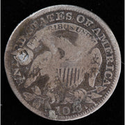 Reverse of holed 1829 Capped Bust dime showing eagle design, scratches, and circulated silver surfaces